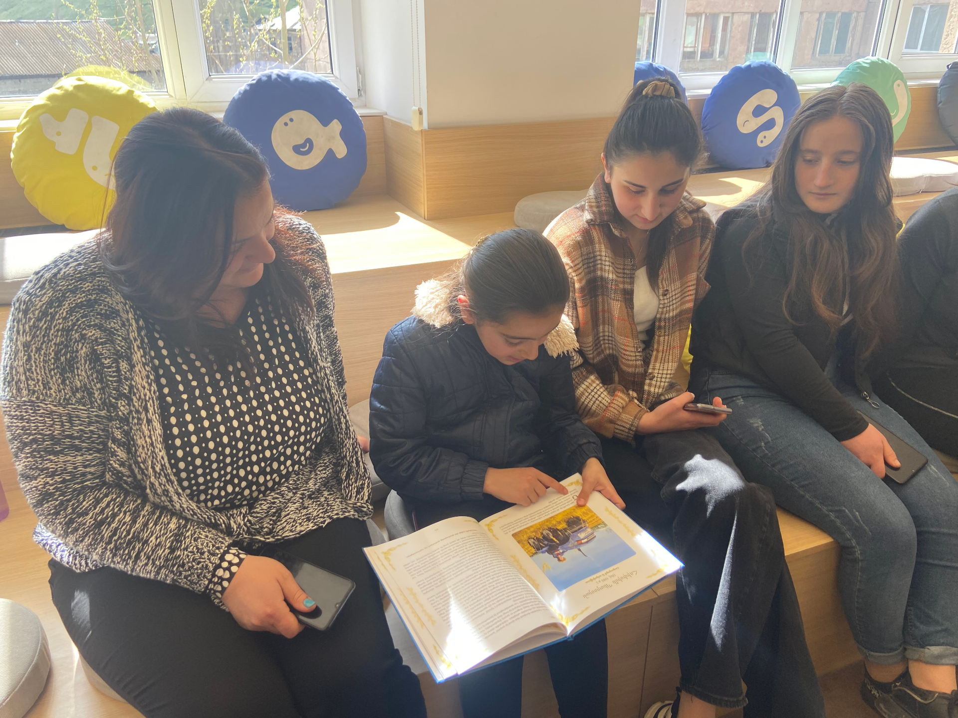 Girls reading one of the books together in a bright reading corner